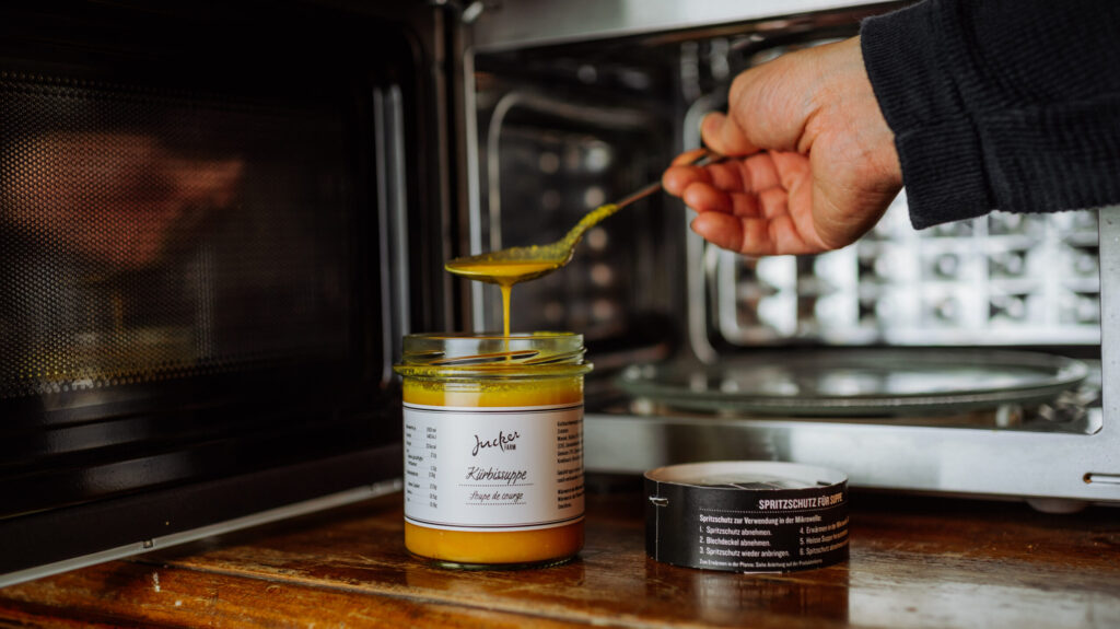 Mini Suppe mit Mikrowellendeckel Kürbissuppe wird gelöffelt